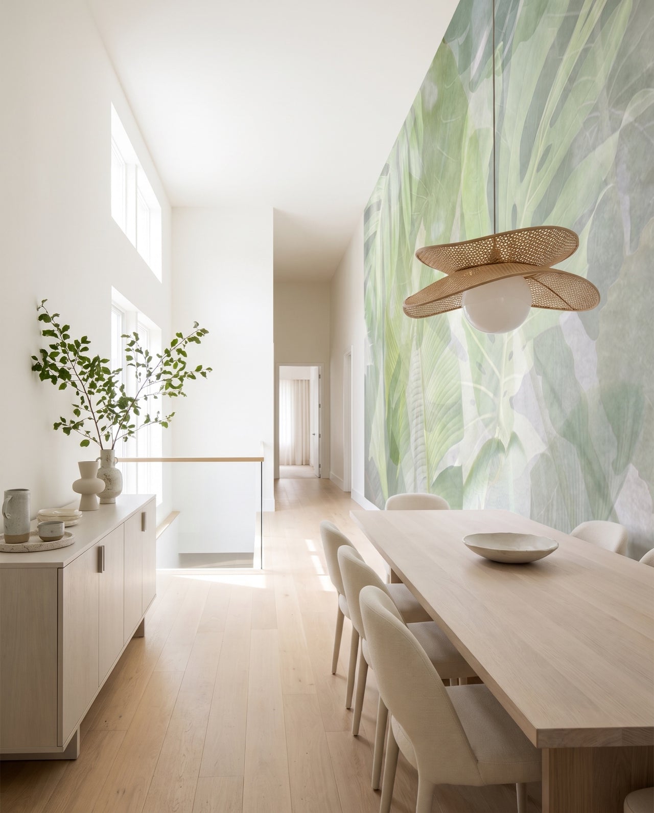 Fresque murale Sève dans une salle à manger en chêne clair avec suspension en rotin : feuillages aquarelle sur mesure au Maroc, Wonderwall