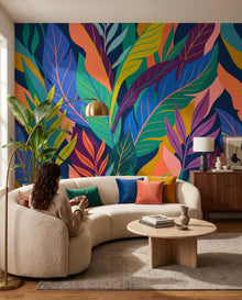 Fresque murale Tulum dans un séjour, une femme assise sur le canapé un café à la main : feuillages tropicaux sur mesure au Maroc, Wonderwall