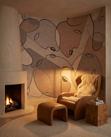Papier peint panoramique Terracina dans un coin lecture à cheminée de plâtre avec fauteuil cuir caramel : fresque line art terracotta Wonderwall Casablanca