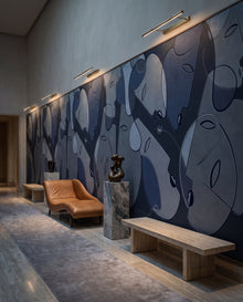 Fresque murale Muse dans une galerie chaise longue cuir caramel : visages line art bleu nuit sur mesure au Maroc, Wonderwall